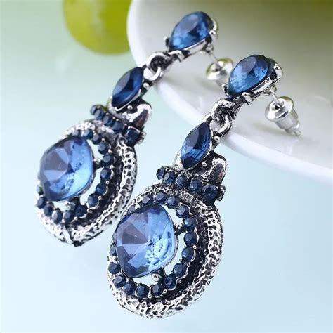 blue crystal earrings dangle.